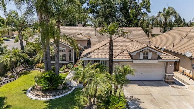 7507 N Constance Ave, Fresno, CA 93722 - mediterranean / spanish-style house with a tiled roof, stucco siding, concrete driveway, a front yard, and an attached garage