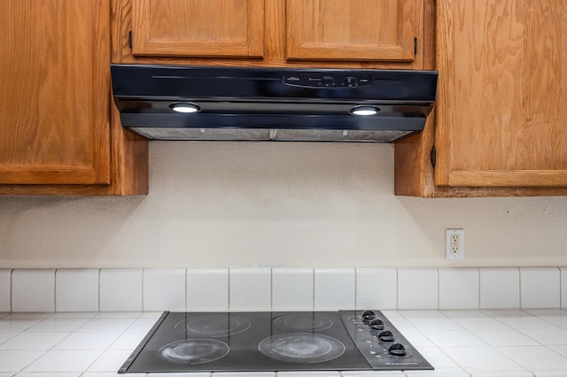 7507 N Constance Ave, Fresno, CA 93722 - kitchen view of ventilation hood, black electric cooktop, light countertops, and brown cabinetry