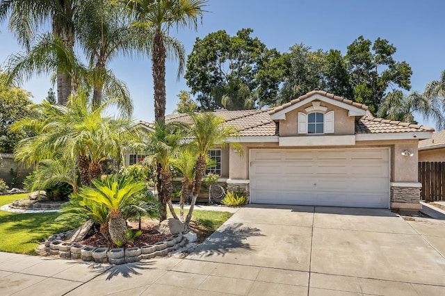 7507 N Constance Ave, Fresno, CA 93722 - mediterranean / spanish-style house featuring stone siding, stucco siding, and driveway