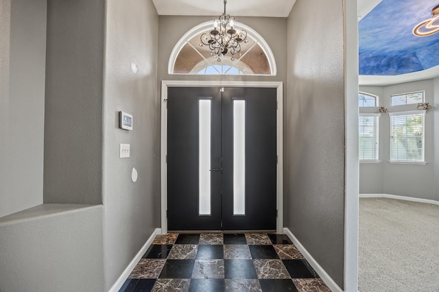 7507 N Constance Ave, Fresno, CA 93722 - foyer entrance with a chandelier, a textured wall, and dark stone finish flooring