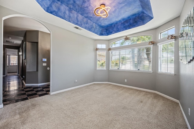 7507 N Constance Ave, Fresno, CA 93722 - spare room featuring arched walkways, a tray ceiling, and carpet flooring