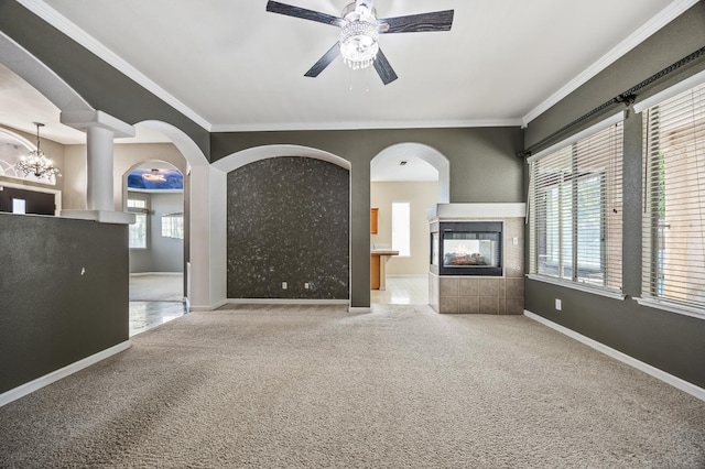 7507 N Constance Ave, Fresno, CA 93722 - unfurnished living room with carpet, a multi sided fireplace, a ceiling fan, ornamental molding, and arched walkways