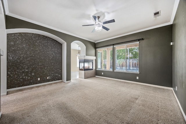 7507 N Constance Ave, Fresno, CA 93722 - unfurnished living room featuring carpet flooring, a ceiling fan, crown molding, arched walkways, and a multi sided fireplace
