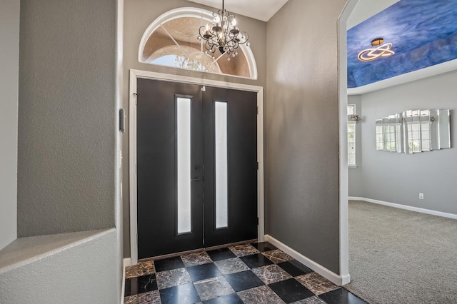 7507 N Constance Ave, Fresno, CA 93722 - foyer featuring a chandelier, plenty of natural light, arched walkways, a textured wall, and carpet flooring
