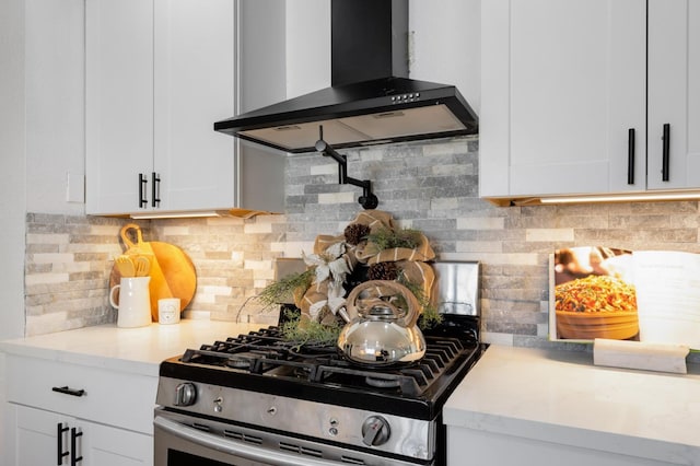 438 E Cortland Ave, Fresno, CA 93704 - kitchen with wall chimney range hood, gas range, white cabinetry, and decorative backsplash