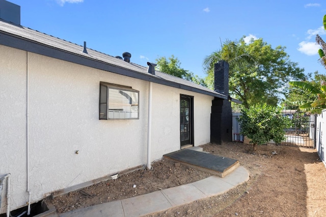438 E Cortland Ave, Fresno, CA 93704 - property entrance featuring stucco siding and a chimney