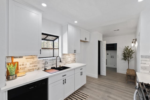 438 E Cortland Ave, Fresno, CA 93704 - kitchen with black dishwasher, gas stove, backsplash, white cabinets, and light countertops