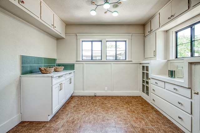 730 E Yale Ave, Fresno, CA 93704 - kitchen featuring plenty of natural light, light countertops, a textured ceiling, and white cabinets