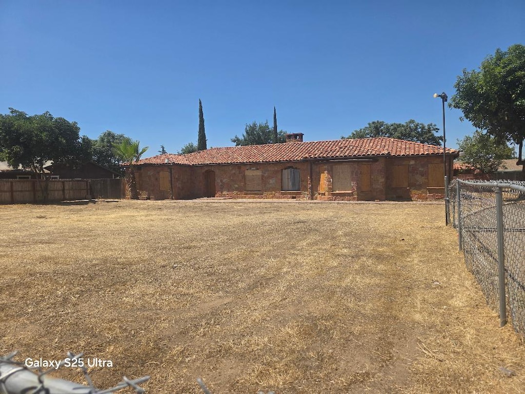 4933 E Tulare Ave, Fresno, CA 93727 - rear view of property featuring a tiled roof and stucco siding