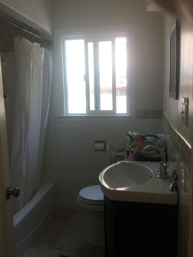 411 E Fountain Way, Fresno, CA 93704 - full bath featuring vanity, tile walls, shower / bath combo, and tile patterned floors