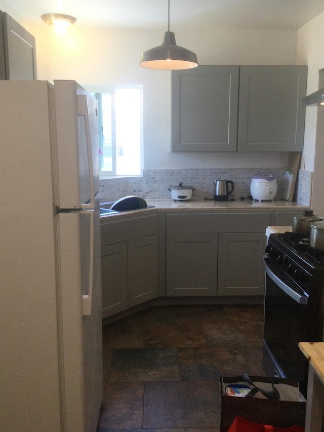 411 E Fountain Way, Fresno, CA 93704 - kitchen featuring freestanding refrigerator, black range with gas stovetop, light countertops, and backsplash