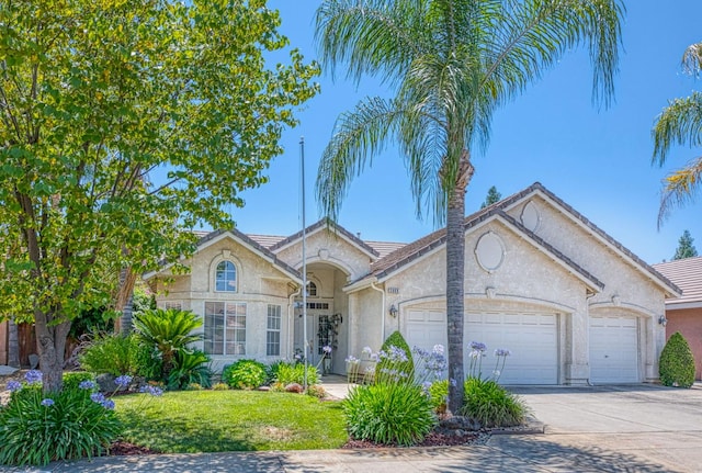 2869 E Brandon Ln, Fresno, CA 93720 - view of front of home with an attached garage, stucco siding, concrete driveway, and a tile roof
