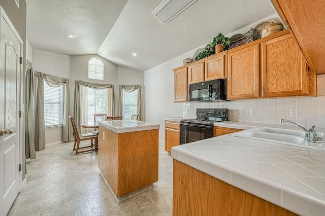 2869 E Brandon Ln, Fresno, CA 93720 - kitchen with black appliances, vaulted ceiling, tile counters, a center island, and decorative backsplash