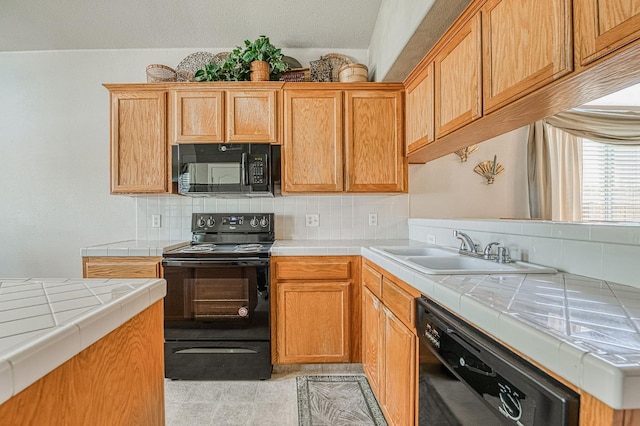2869 E Brandon Ln, Fresno, CA 93720 - kitchen with black appliances, tile countertops, and tasteful backsplash