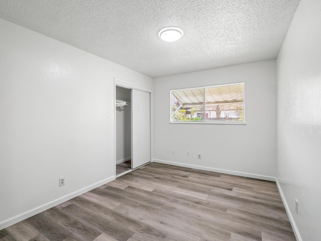 4629 N Fisher St, Fresno, CA 93726 - unfurnished bedroom featuring a textured ceiling, wood finished floors, and a closet