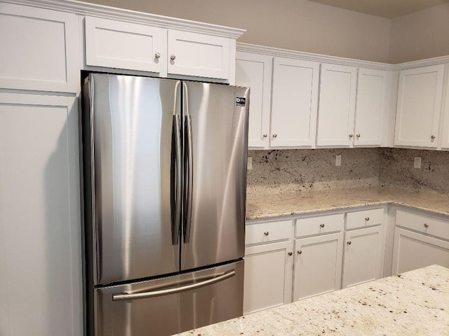 3869 Griffith Ave, Clovis, CA 93619 - kitchen with freestanding refrigerator, white cabinets, and light stone countertops