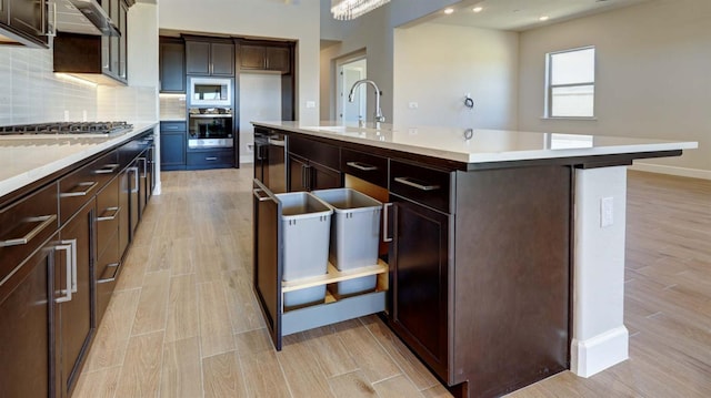925 Talus Way S, Madera, CA 93636 - kitchen featuring appliances with stainless steel finishes, light countertops, light wood-type flooring, backsplash, and recessed lighting