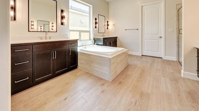 925 Talus Way S, Madera, CA 93636 - full bathroom with wood finished floors, two vanities, a stall shower, and a bath