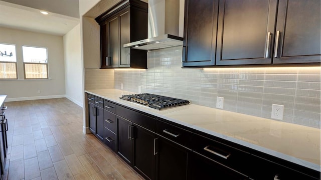 925 Talus Way S, Madera, CA 93636 - kitchen featuring wall chimney range hood, stainless steel gas stovetop, backsplash, and light stone countertops