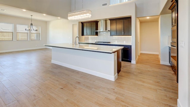 925 Talus Way S, Madera, CA 93636 - kitchen featuring a chandelier, wall chimney exhaust hood, appliances with stainless steel finishes, light countertops, and backsplash