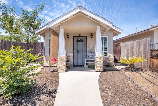 51 E Tuolumne St, Fresno, CA 93706 - entrance to property featuring stone siding, stucco siding, and covered porch