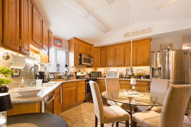 51 E Tuolumne St, Fresno, CA 93706 - kitchen featuring appliances with stainless steel finishes, tasteful backsplash, brown cabinetry, vaulted ceiling, and light countertops