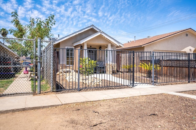 51 E Tuolumne St, Fresno, CA 93706 - view of front facade with a fenced front yard, a gate, and stucco siding