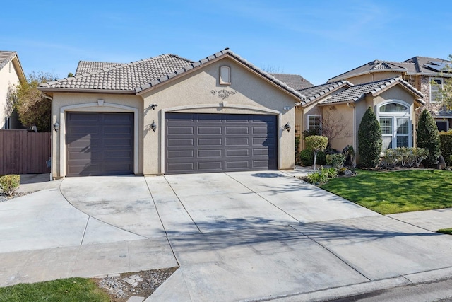 2639 Maine Ave, Clovis, CA 93619 - mediterranean / spanish house featuring a garage, concrete driveway, stucco siding, and a tile roof