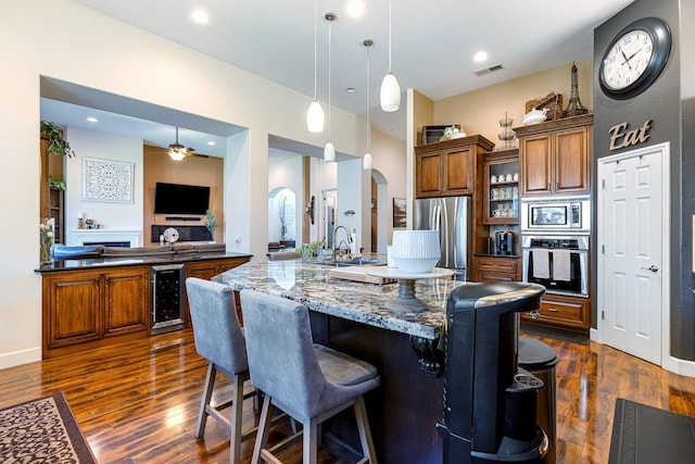 2639 Maine Ave, Clovis, CA 93619 - kitchen with appliances with stainless steel finishes, beverage cooler, arched walkways, and brown cabinets