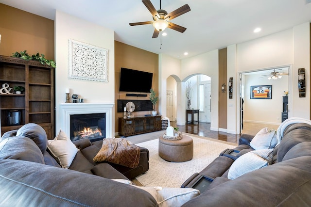 2639 Maine Ave, Clovis, CA 93619 - living room with ceiling fan, arched walkways, recessed lighting, a glass covered fireplace, and wood finished floors
