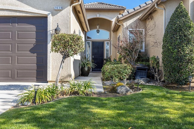 2639 Maine Ave, Clovis, CA 93619 - property entrance featuring stucco siding, a lawn, an attached garage, and a tiled roof