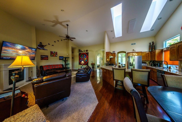 9930 N Rowell Ave, Fresno, CA 93720 - living area with dark wood-style flooring, high vaulted ceiling, a skylight, and ceiling fan