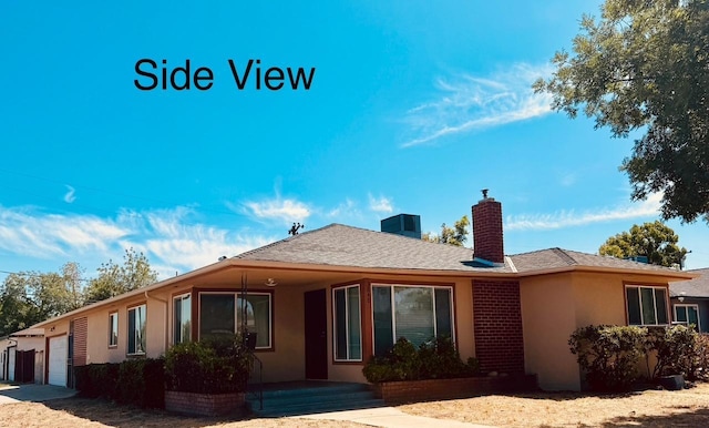 3646 E Dayton Ave, Fresno, CA 93726 - rear view of house with a garage, a chimney, stucco siding, and roof with shingles