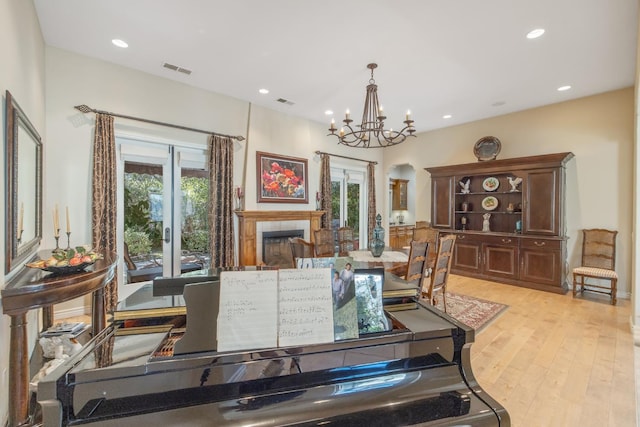 4638 W Lark Ct, Visalia, CA 93291 - dining room with a chandelier, light wood-style flooring, recessed lighting, arched walkways, and a tile fireplace