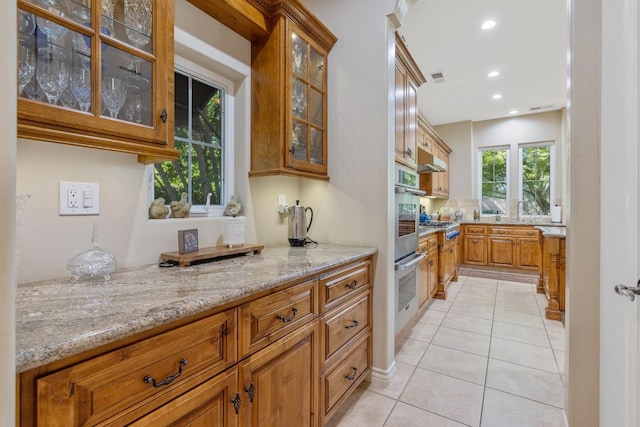 4638 W Lark Ct, Visalia, CA 93291 - kitchen featuring light tile patterned flooring, light stone counters, brown cabinets, stainless steel appliances, and recessed lighting