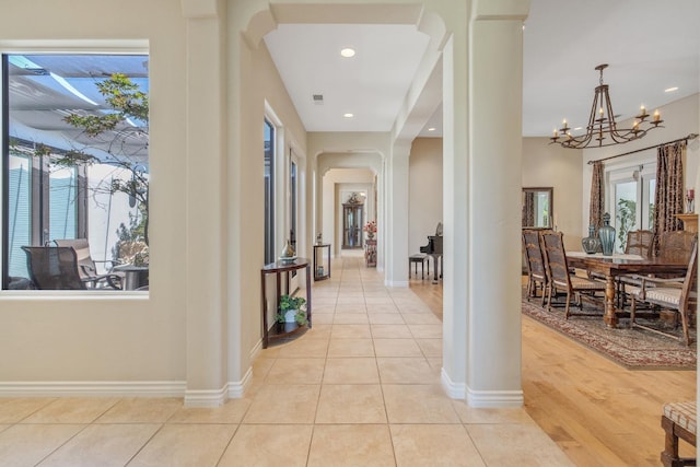 4638 W Lark Ct, Visalia, CA 93291 - hall featuring arched walkways, ornate columns, a chandelier, light tile patterned flooring, and recessed lighting
