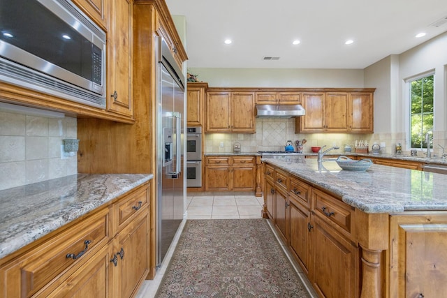 4638 W Lark Ct, Visalia, CA 93291 - kitchen with built in appliances, tasteful backsplash, brown cabinets, and recessed lighting