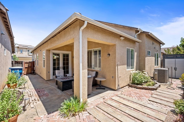 5313 W King Fisher Ln, Fresno, CA 93722 - back of house featuring a patio, stucco siding, and an outdoor fire pit