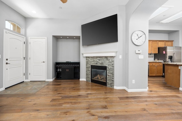 5313 W King Fisher Ln, Fresno, CA 93722 - unfurnished living room featuring light wood-style floors, recessed lighting, a stone fireplace, and ceiling fan