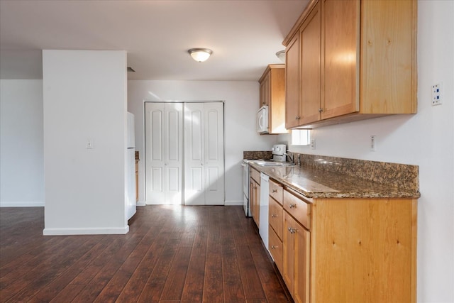 40885 Elliott Dr, Oakhurst, CA 93644 - kitchen with dark wood-style floors, dark stone countertops, and white appliances