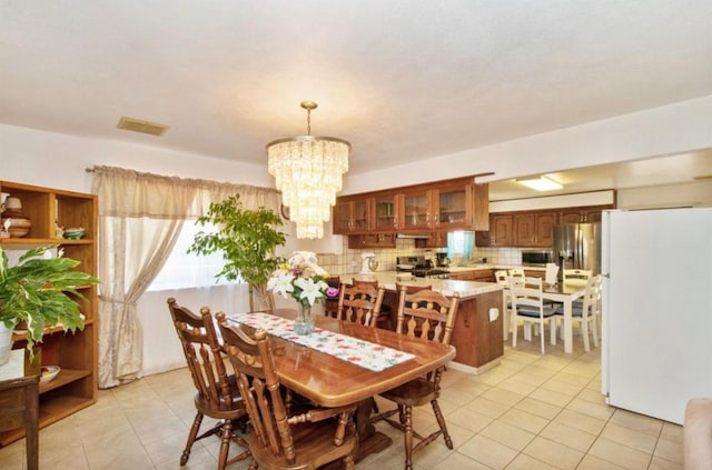12420 S Chestnut Ave, Fresno, CA 93725 - dining area with light tile patterned flooring and a chandelier