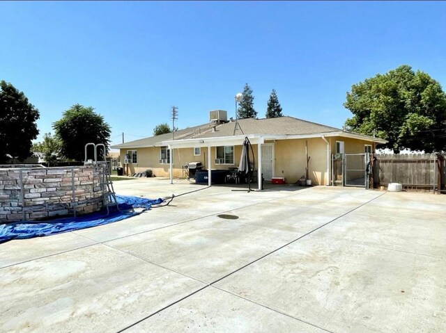 12420 S Chestnut Ave, Fresno, CA 93725 - back of house featuring stucco siding, a patio, and a gate
