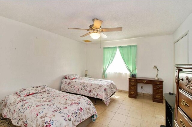 12420 S Chestnut Ave, Fresno, CA 93725 - bedroom featuring light tile patterned floors, ceiling fan, and a textured ceiling