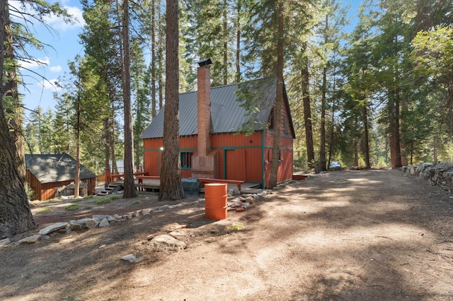 83634 Presidents Ln, Wilsonia, CA 93633 - view of home's exterior with a chimney, a metal roof, a barn, and an outdoor structure