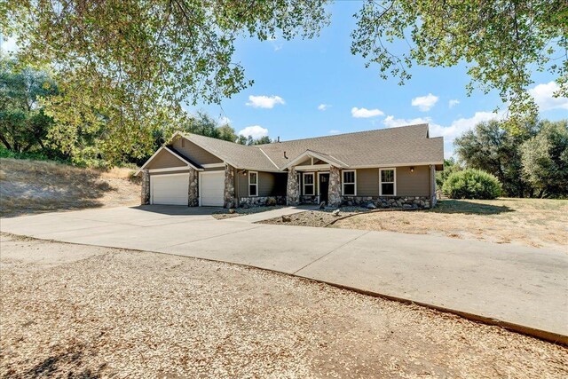 46453 Opah Dr, Ahwahnee, CA 93601 - single story home with stone siding, an attached garage, concrete driveway, and a shingled roof