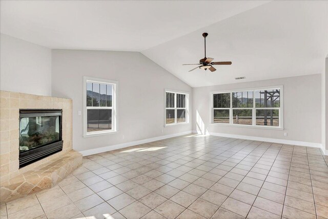 46453 Opah Dr, Ahwahnee, CA 93601 - unfurnished living room featuring light tile patterned floors, a glass covered fireplace, lofted ceiling, a ceiling fan, and healthy amount of natural light