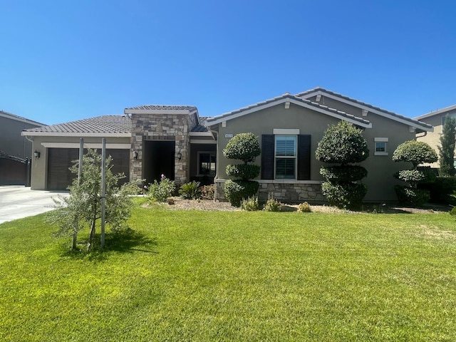 803 E Aretha Ave, Fowler, CA 93625 - view of front of house with an attached garage, a front yard, stone siding, and concrete driveway