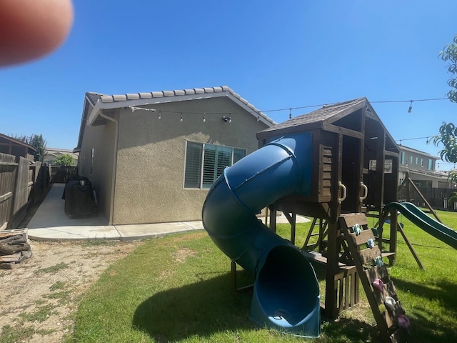 803 E Aretha Ave, Fowler, CA 93625 - rear view of property featuring a playground and stucco siding