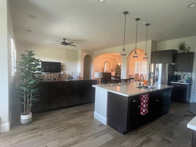 803 E Aretha Ave, Fowler, CA 93625 - kitchen featuring arched walkways, stainless steel fridge, open floor plan, a ceiling fan, and wood finished floors