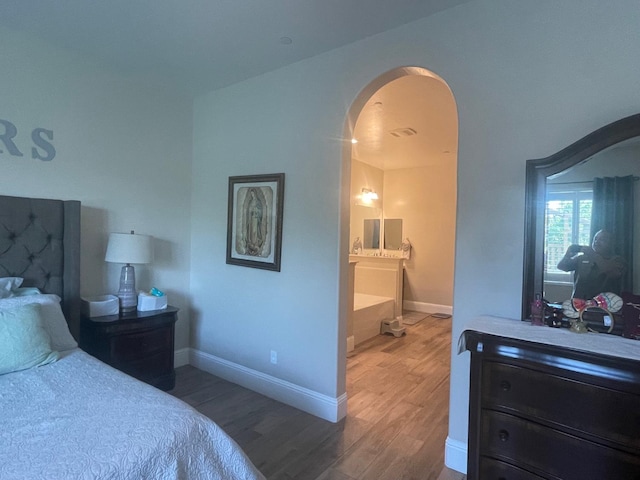 803 E Aretha Ave, Fowler, CA 93625 - bedroom with arched walkways, wood finished floors, and connected bathroom